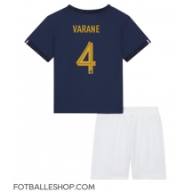 Frankrike Raphael Varane #4 Replika Hjemmedrakt Barn VM 2022 Kortermet (+ bukser)